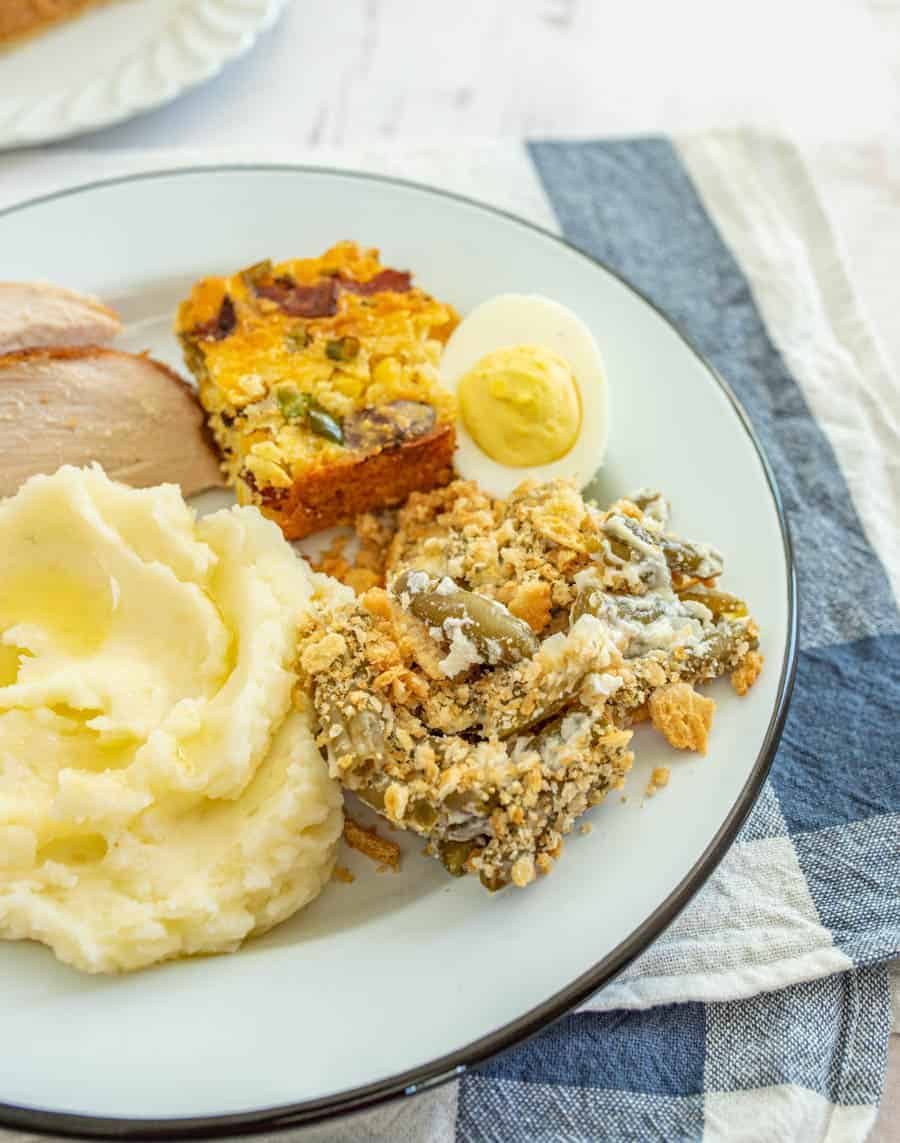 a dinner plate of holiday classics highlighting specifically grandmas green bean casserole.