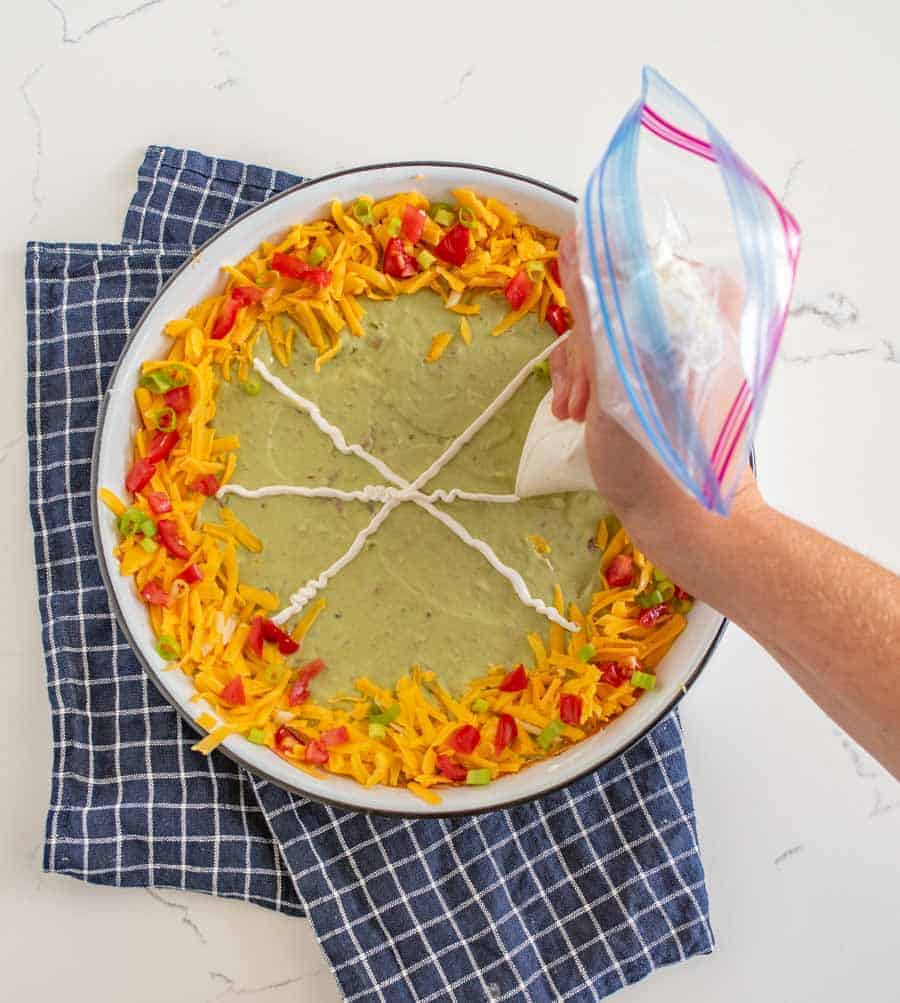 piping the spider webs onto the halloween bean dip.