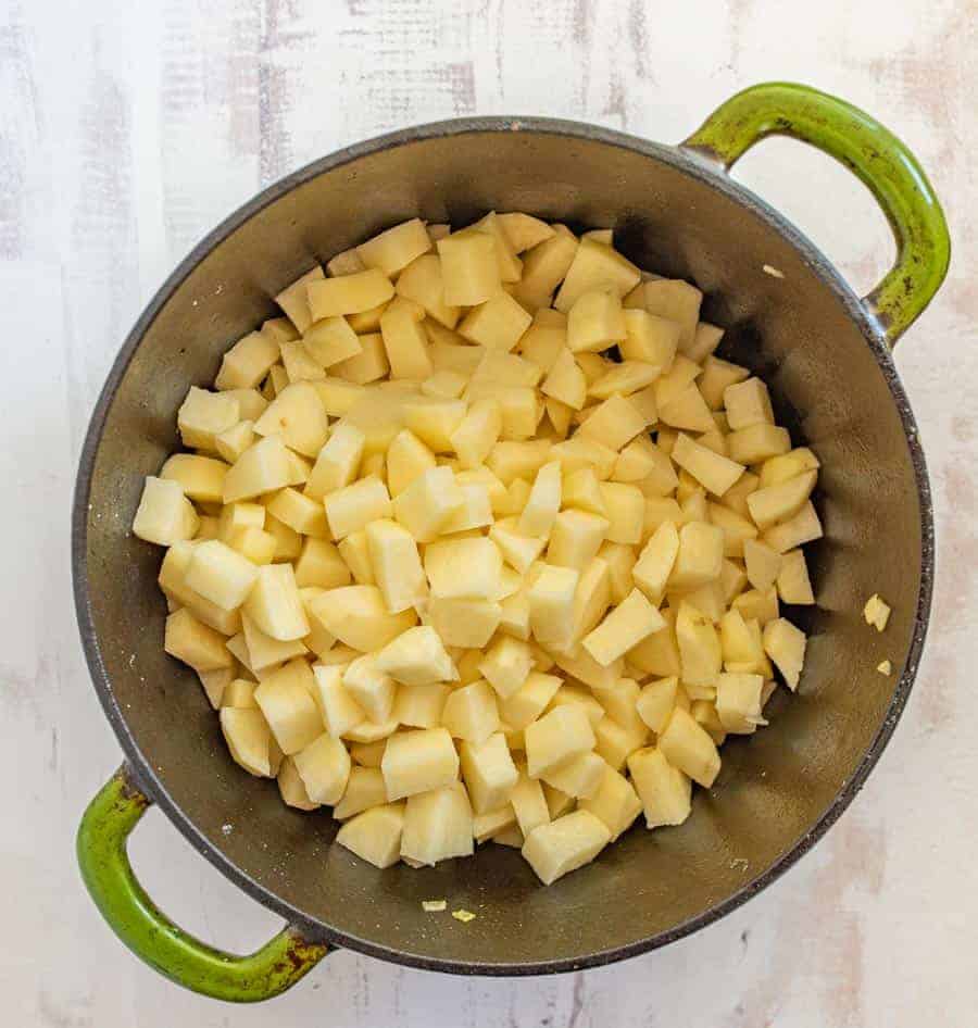 top view of cubed potatoes in a green bowl.