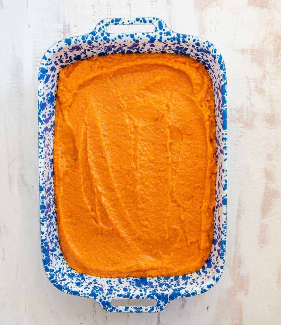 sweet potato casserole in a white and blue pan.