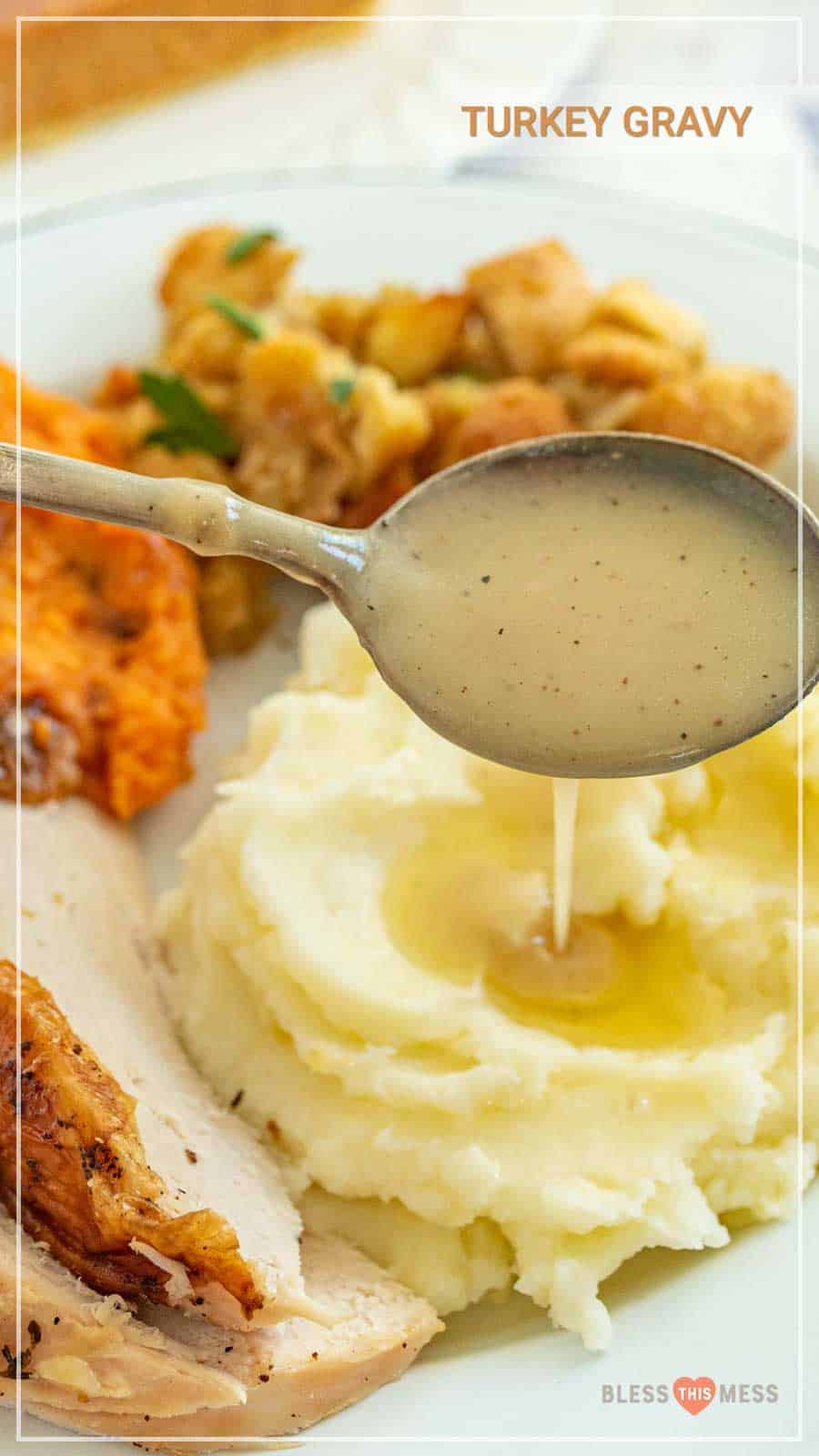 spoon full of gravy dripping over mashed potatoes.