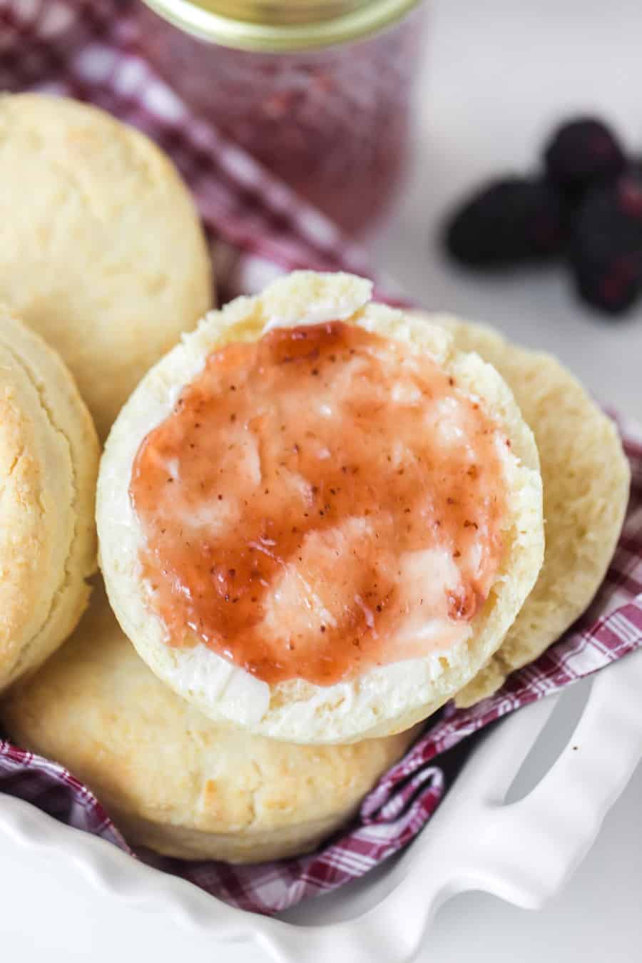simple cream biscuits with jam in white dish.