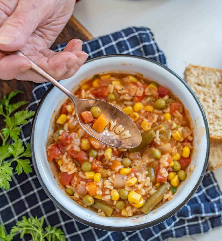 a spoon scooping out the word "yum" out of alphabet soup.