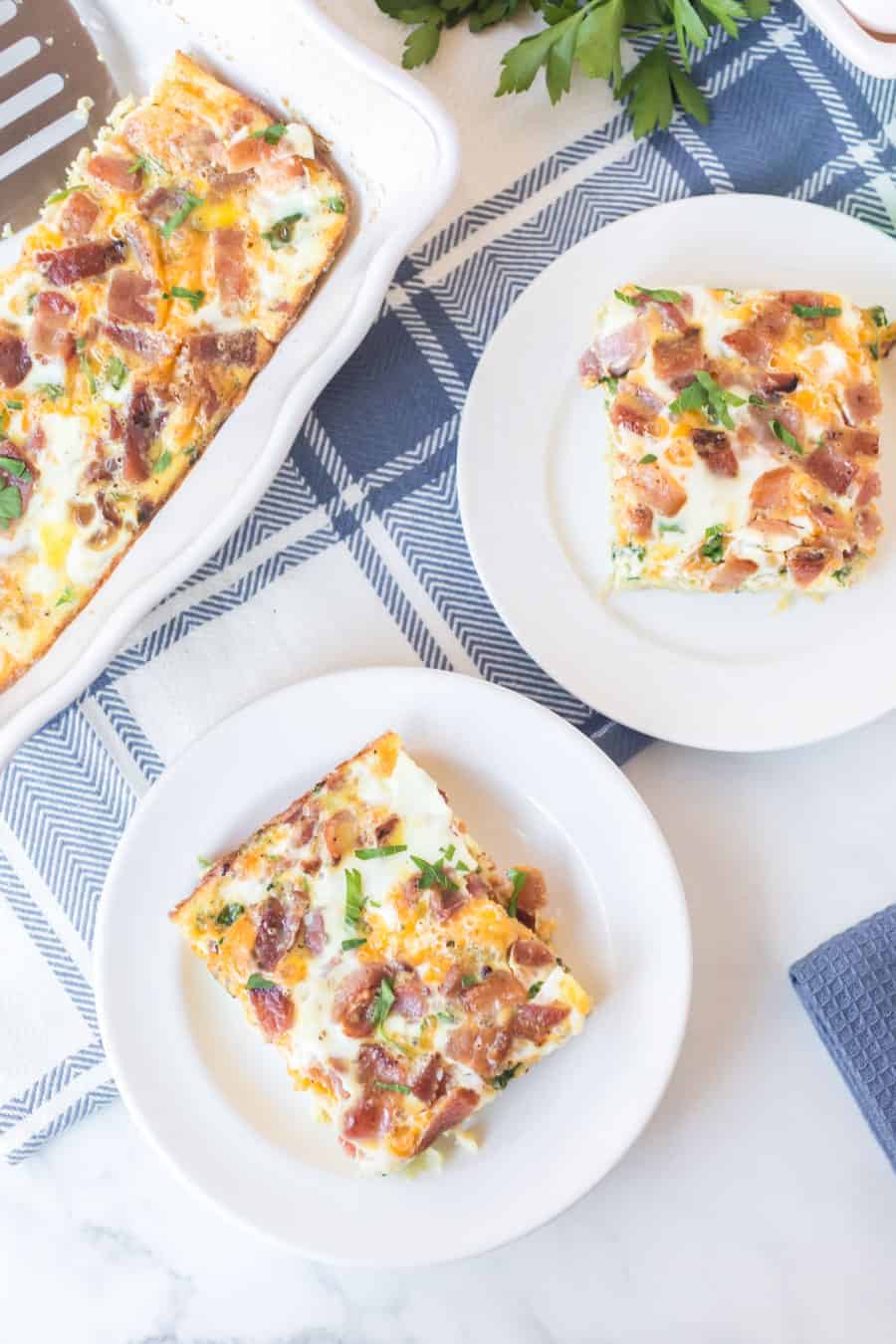 a square of egg bake like quiche without the crust on a white plate with a fork
