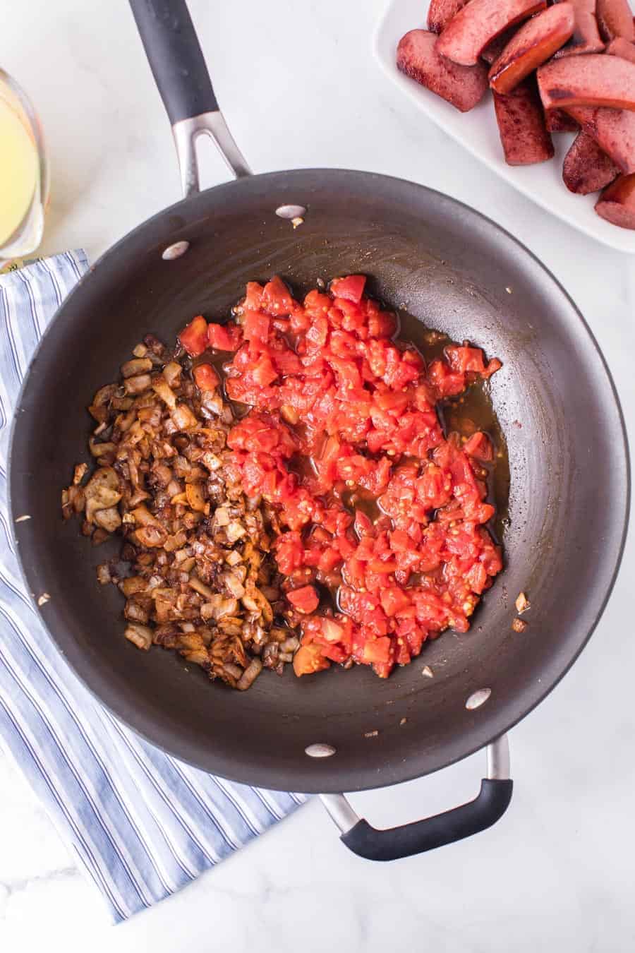 tomatoes and onions being cooked to flavor the lentils.