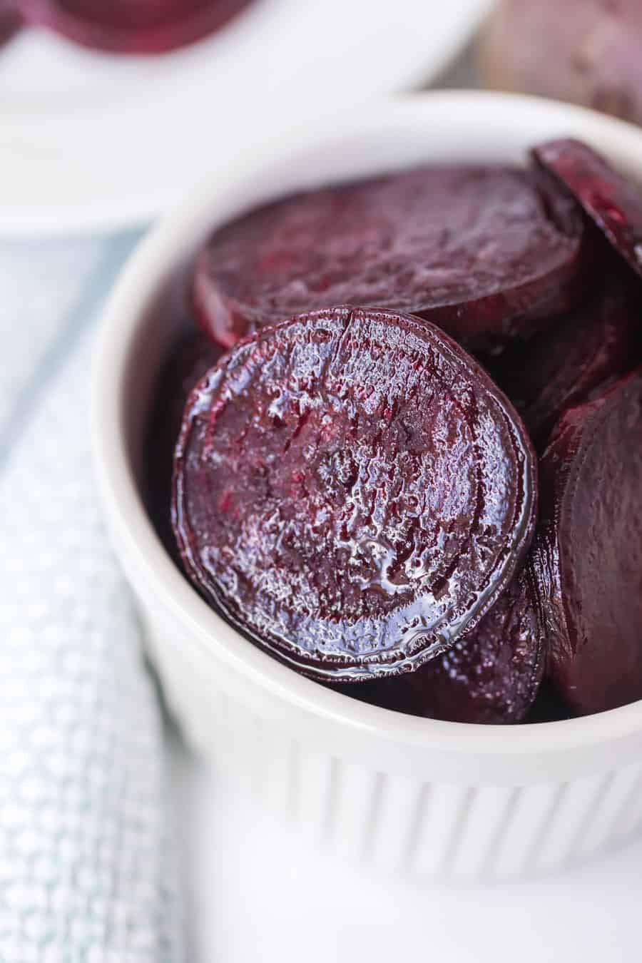 pile of roasted beet slices in a little white dish up close.