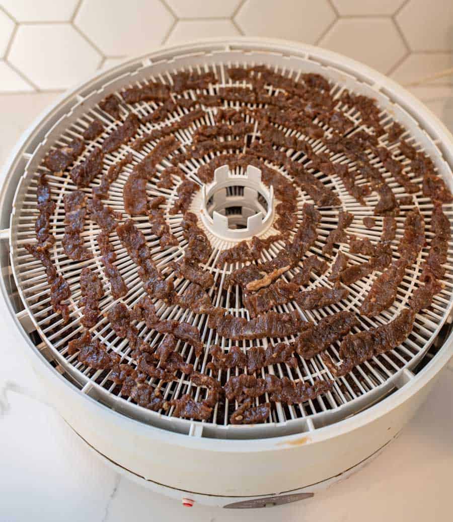 a dehydrator tray full of dried pieces of jerky