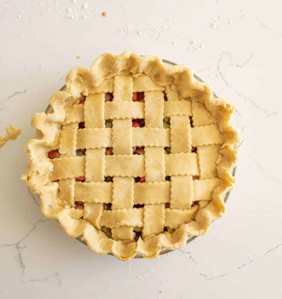 Perfect lattice pie crust on a white marble background.