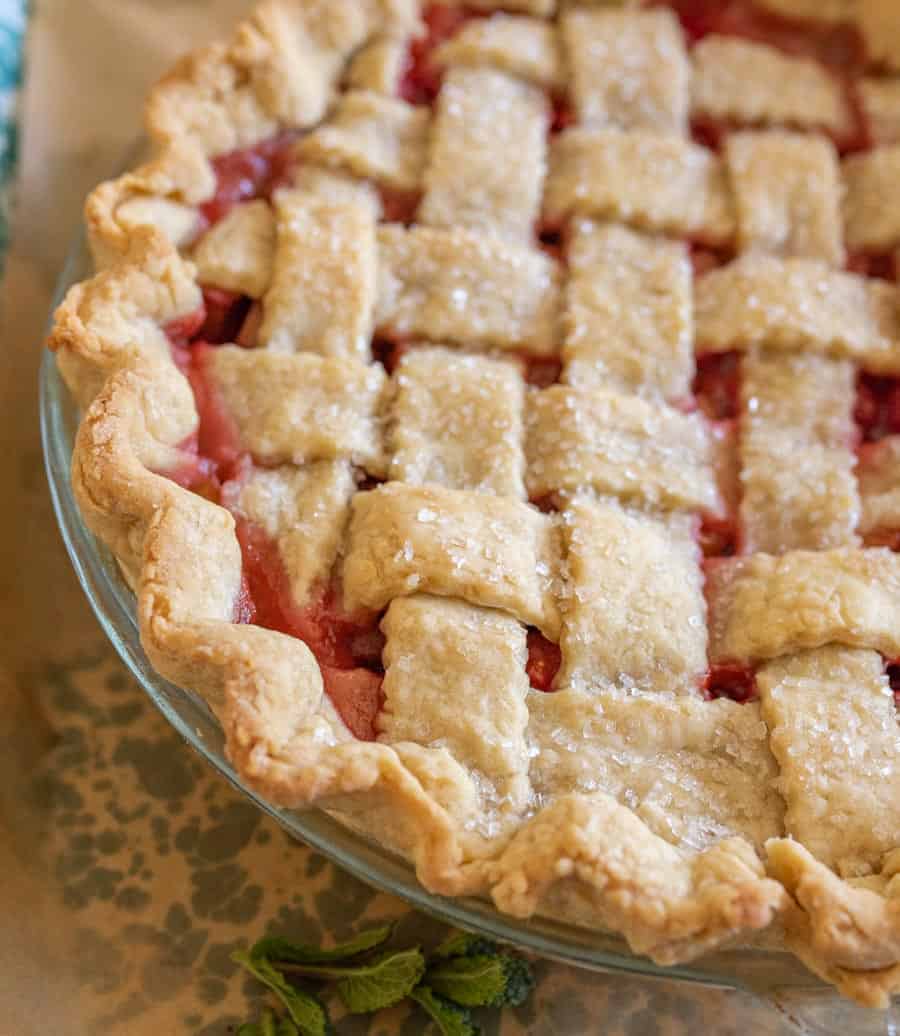 A close up of strawberry rhubarb pie showing off that beautiful lattice crust.