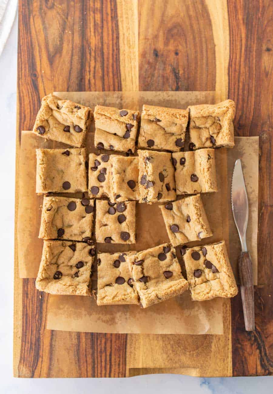 baked cookie bars cut on top of parchment paper.