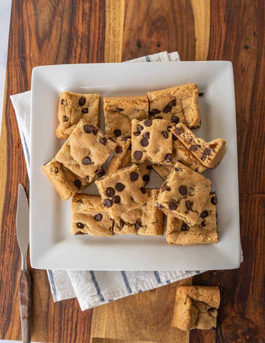 baked and sliced almond flour chocolate chip cookies bars on white serving platter.