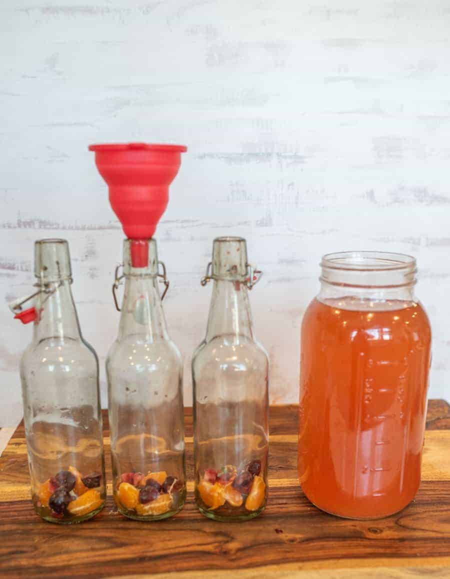 thee open wire lid carafe bottles with funnel ready for jar of first ferment kombucha