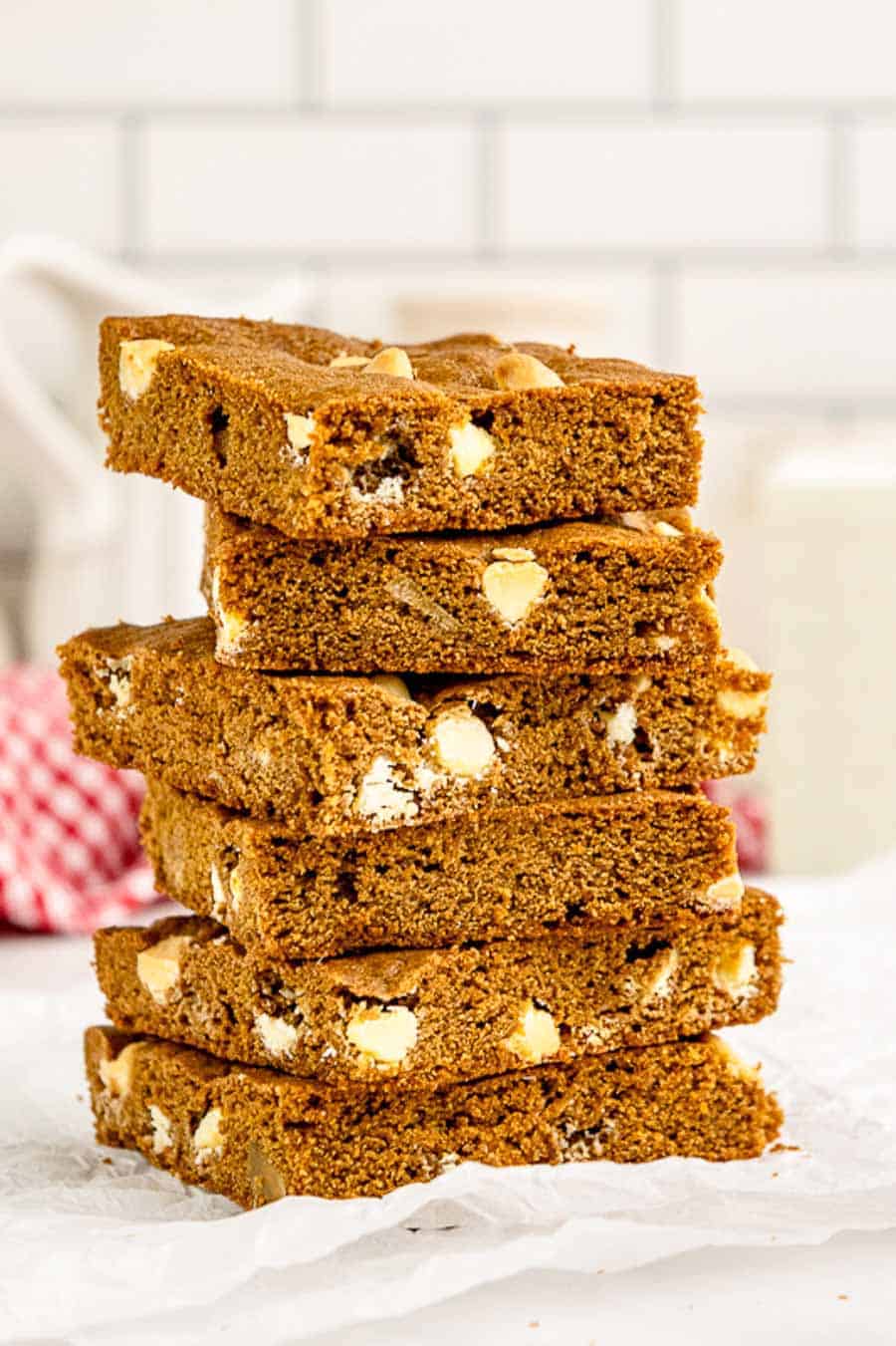 Gingerbread blondie squares on a baking sheet with white parchment paper.