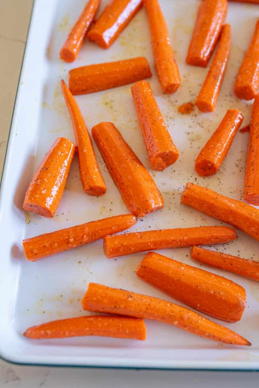 Roasted carrots on a white enamel pan.