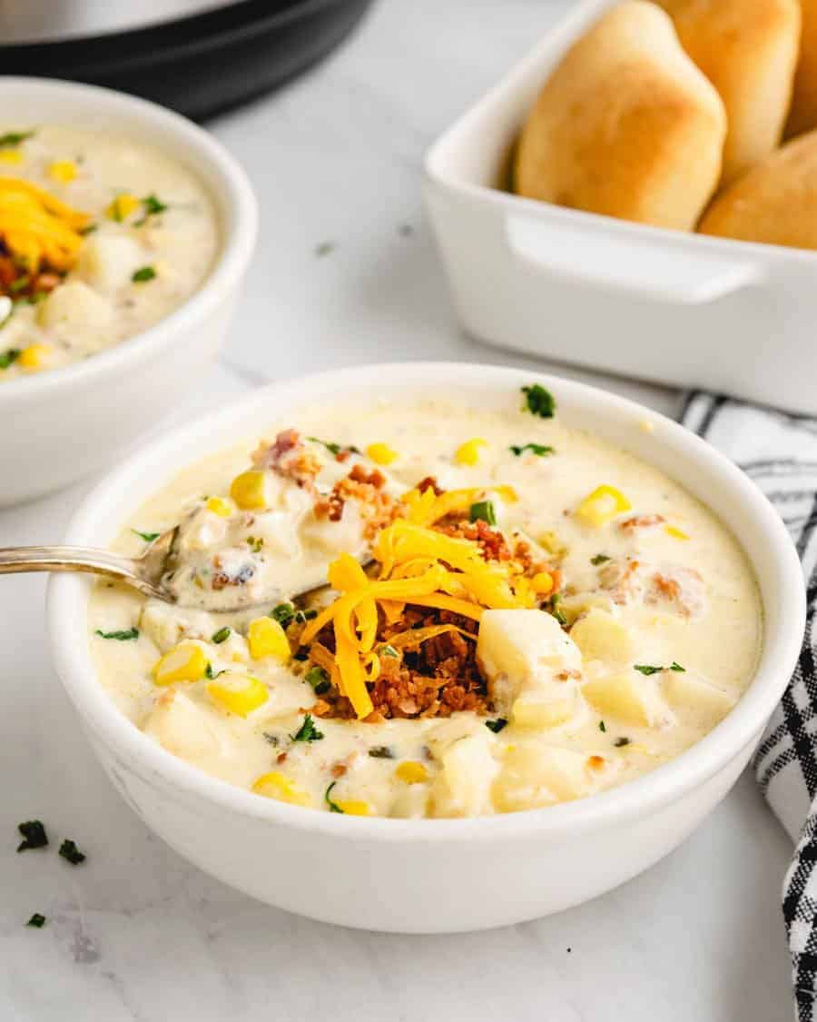 A bowl of potato soup topped with cheese and bacon.