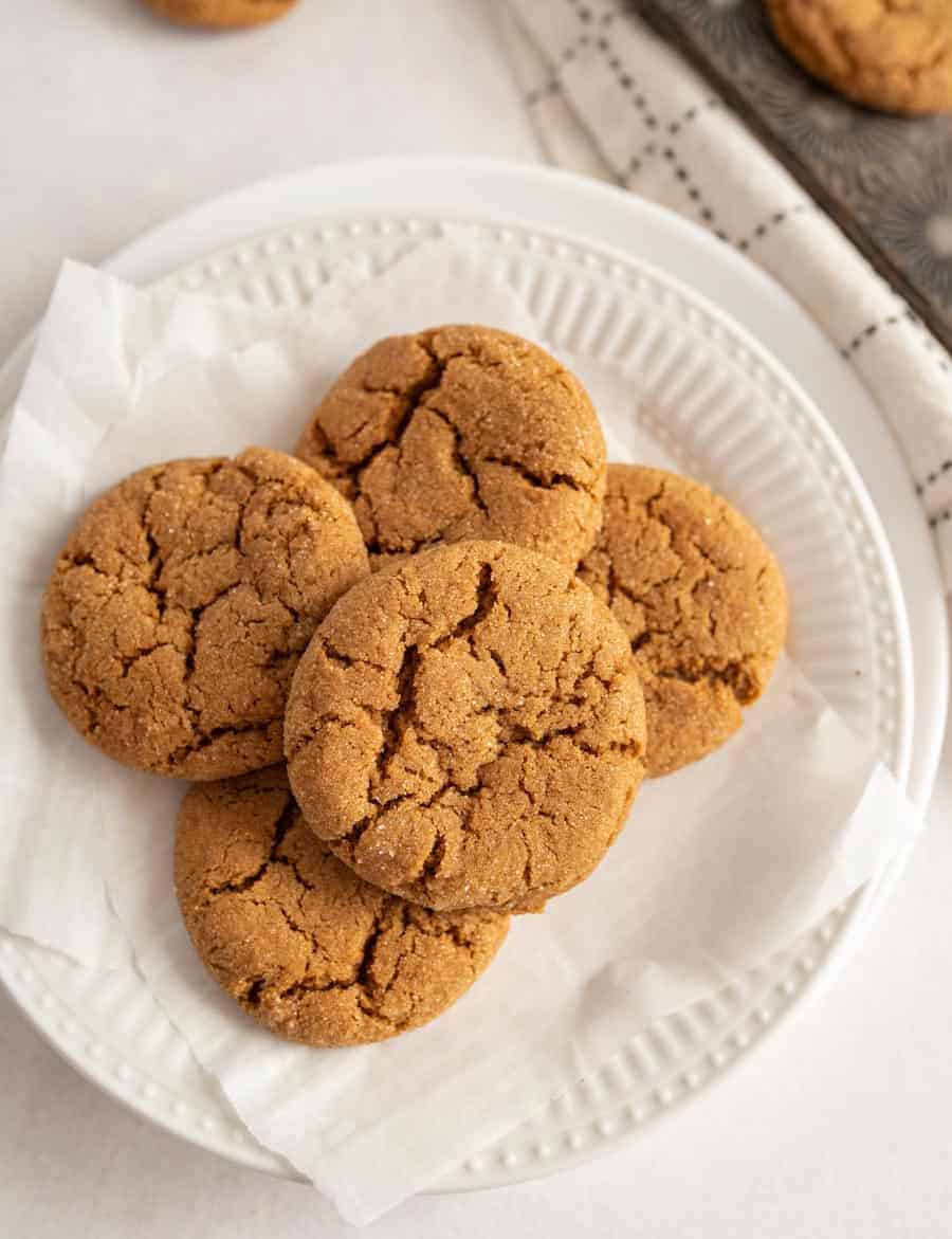 Five old fashioned molasses cookies on a white plate.