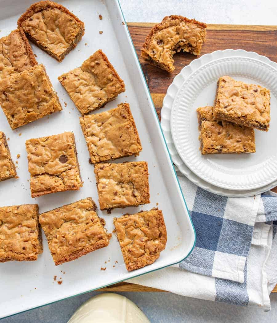 Top view of a pan of blondies with a plate of blondies next to it.