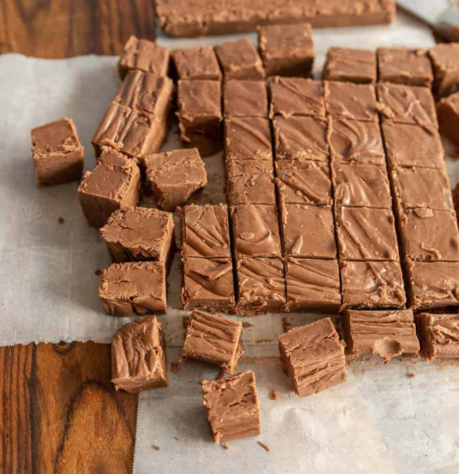 Chocolate fudge cut into squares on parchment paper.