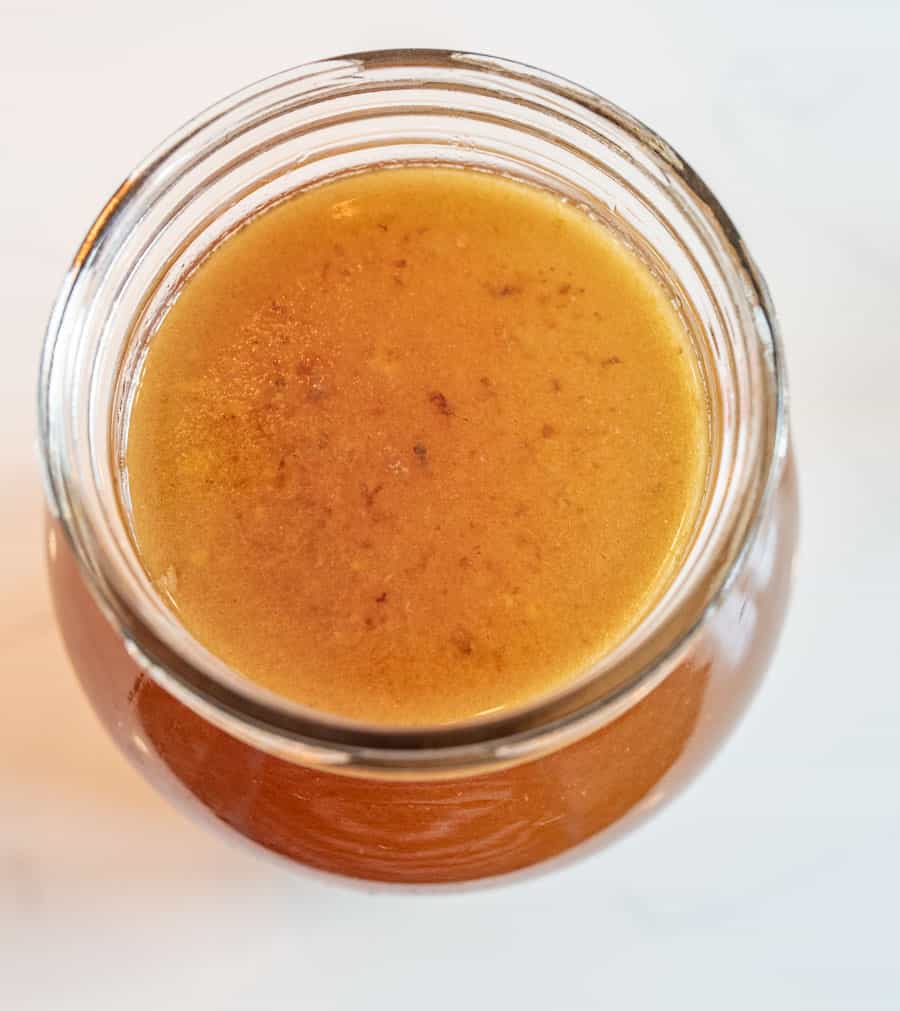 A top view of a glass jar filled with chicken broth.