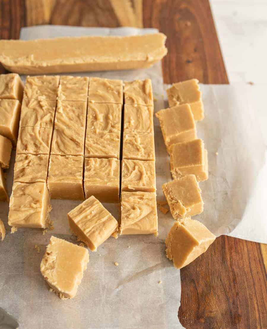 Peanut butter fudge cut into squares on parchment paper.