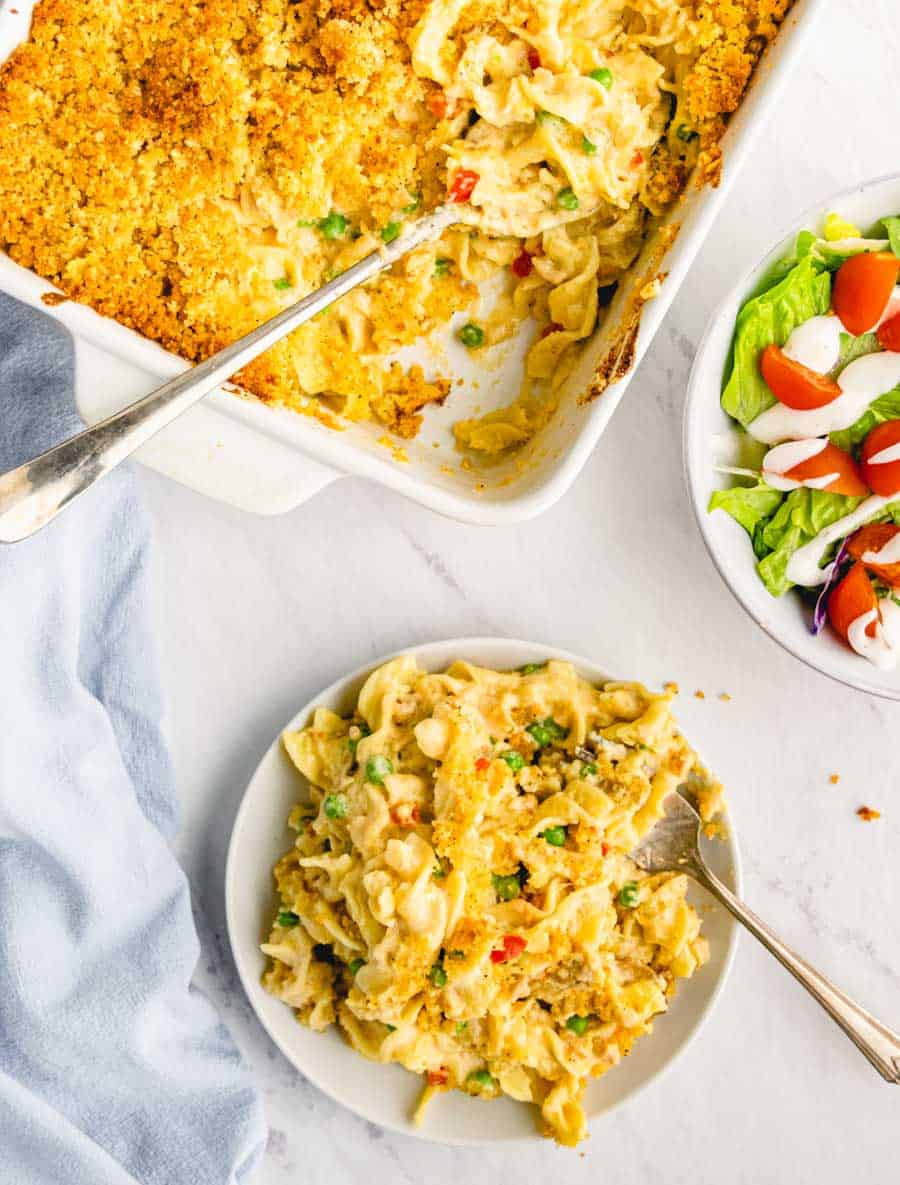 A top view of a plate and dish of tuna noodle casserole.