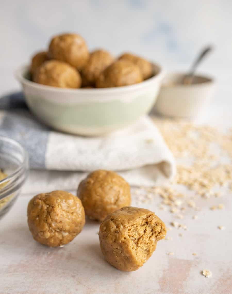 picture of peanut butter protein balls with a bowl of them in the background.