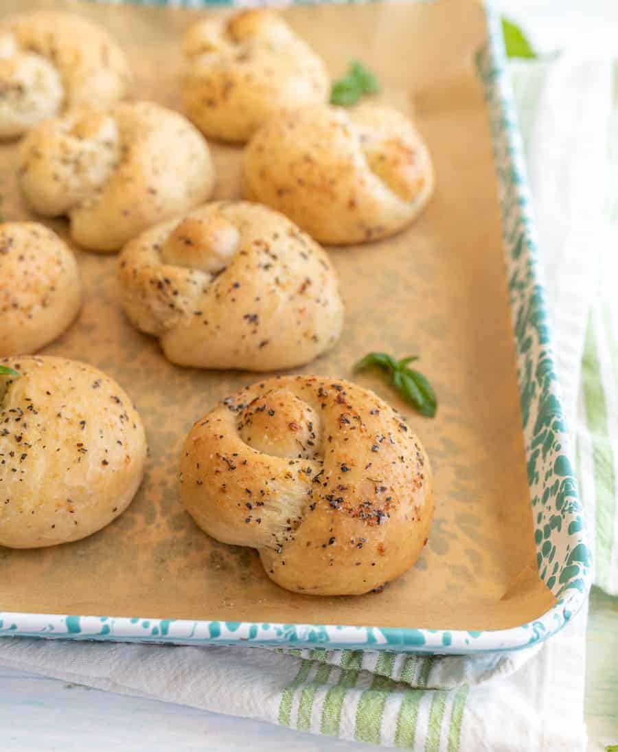 close up picture of garlic knots on a baking sheet.