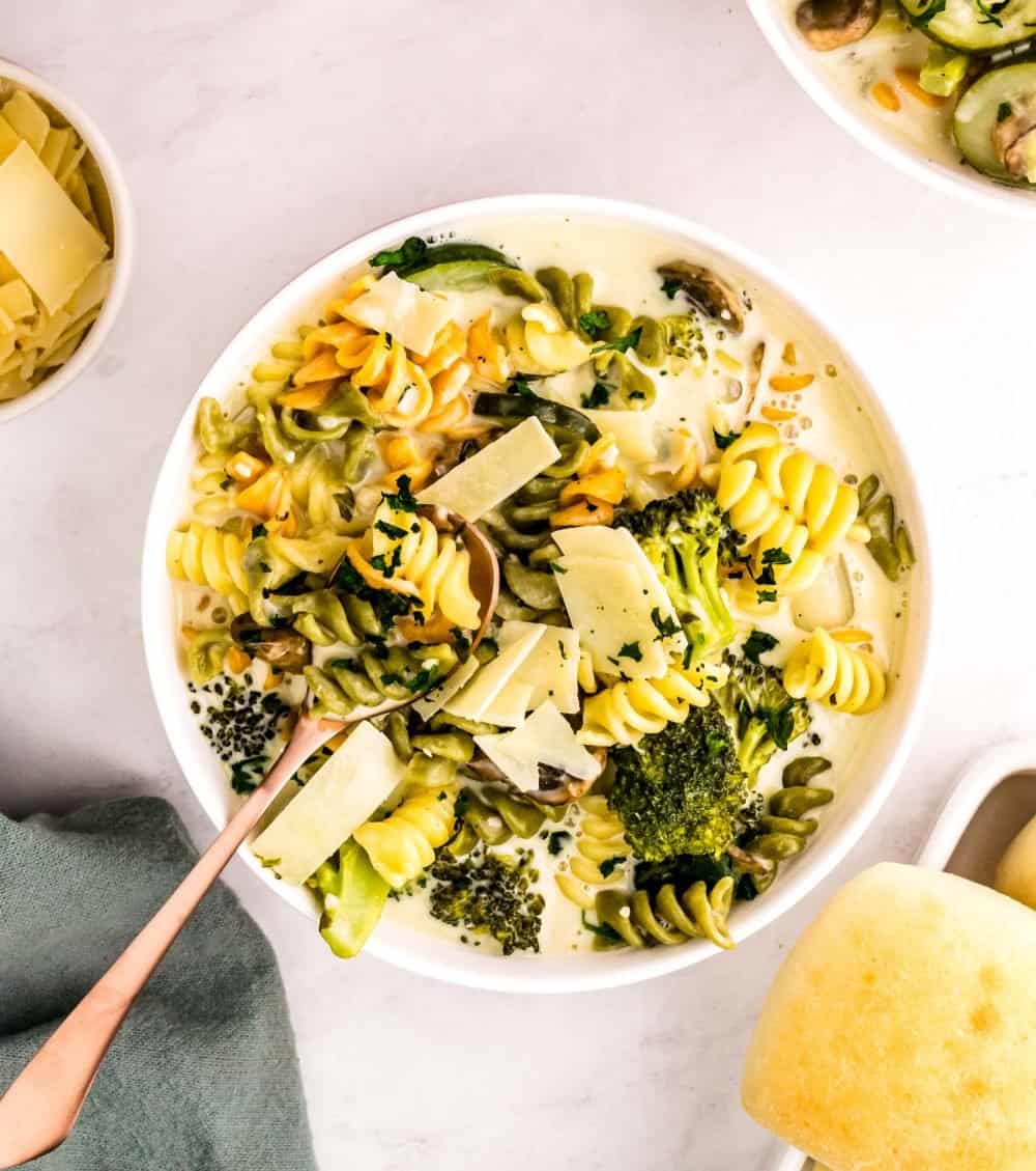 top view of a bowl of pasta primavera with a spoon in it