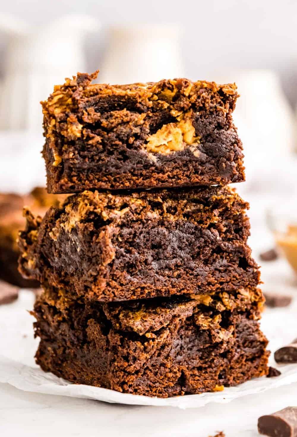A close up of three peanut butter brownie squares stacked on top of each other.