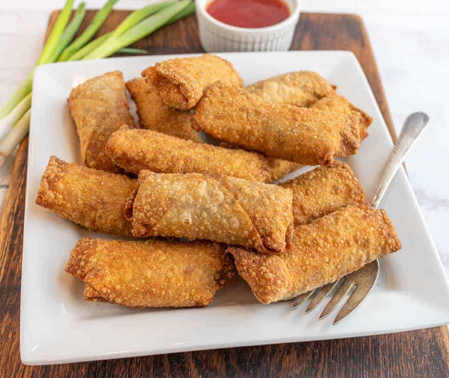 close up of a plate of egg rolls.