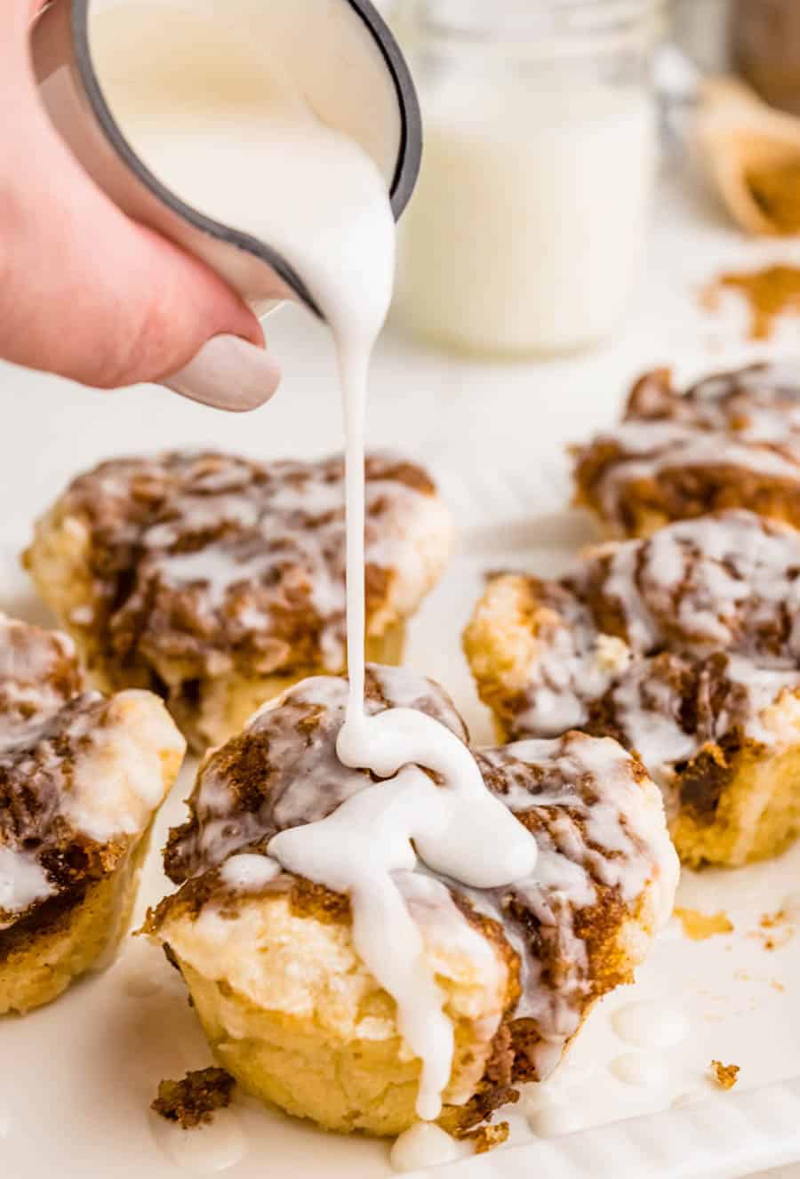 Glaze being poured over monkey bread muffins.