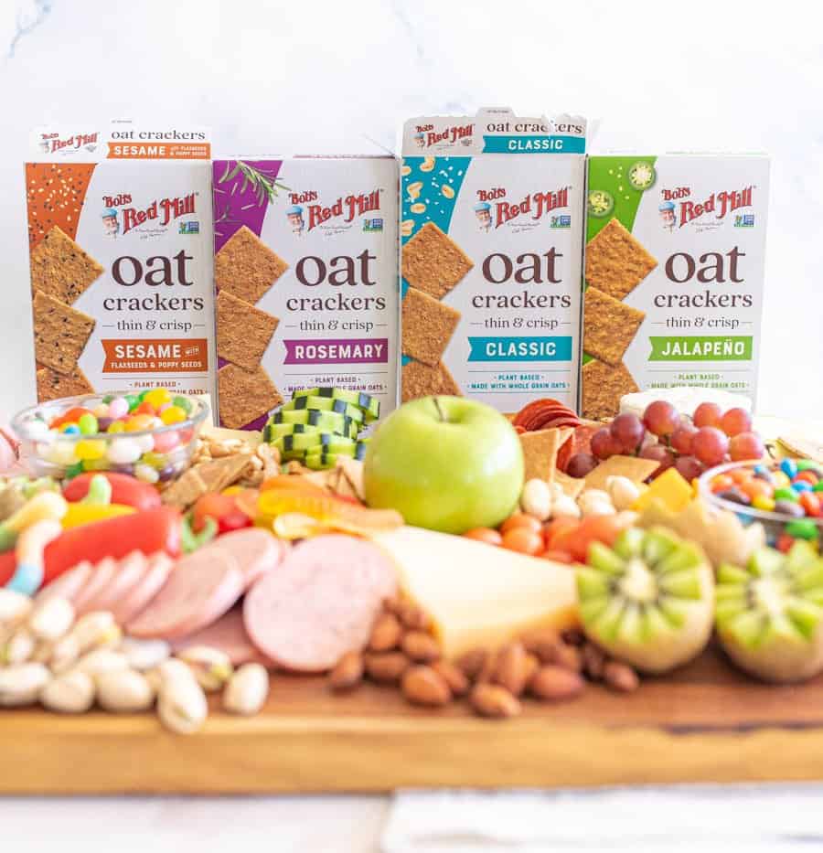 picture of a cheese board with boxes of oat crackers in the background