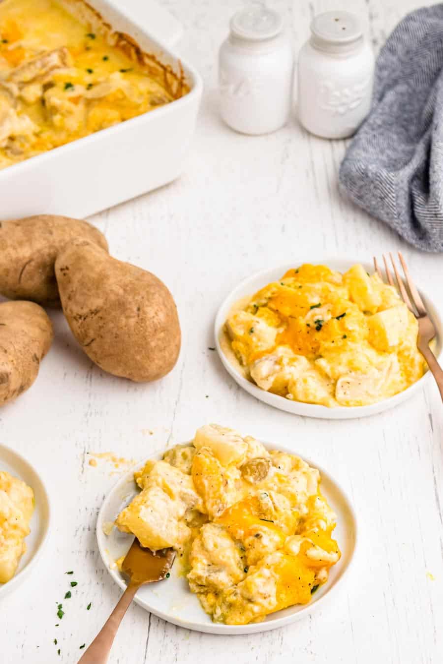 two small plates of au gratin potatoes with forks