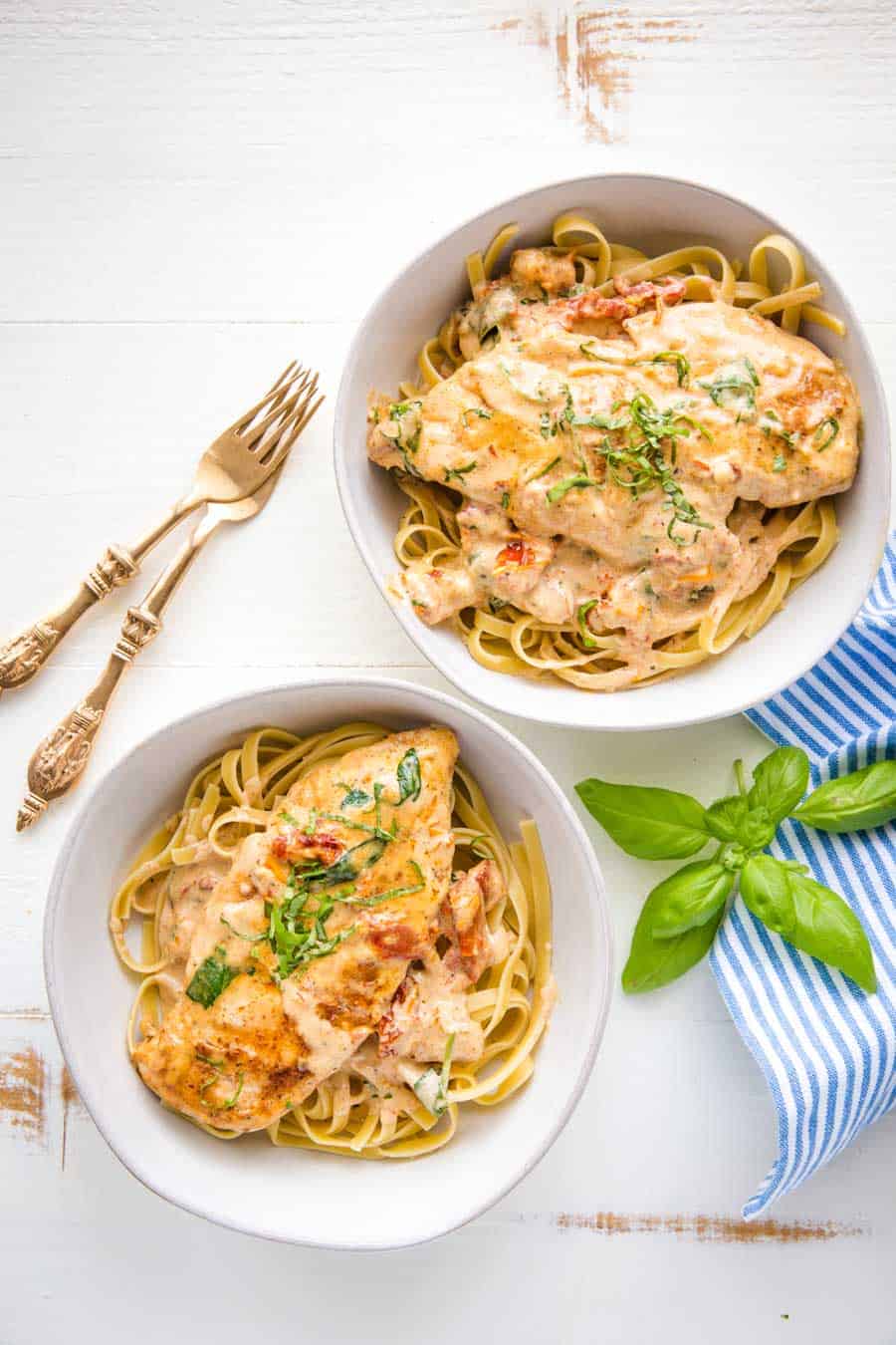 top view of bowls of Tuscan chicken over pasta.