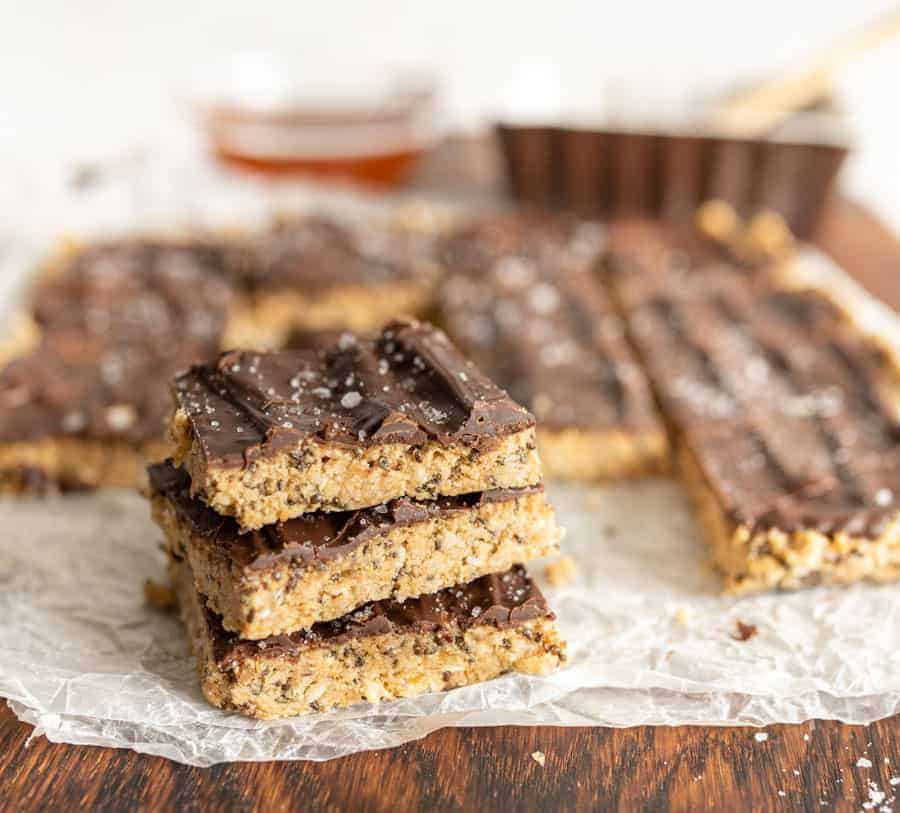a stack of three healthy snack bars with other snack bars behind them