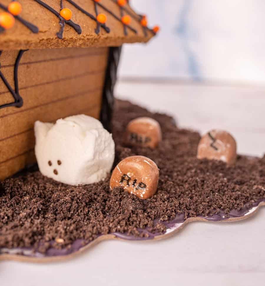 close up view of the tootsie roll headstones next to the Halloween gingerbread house