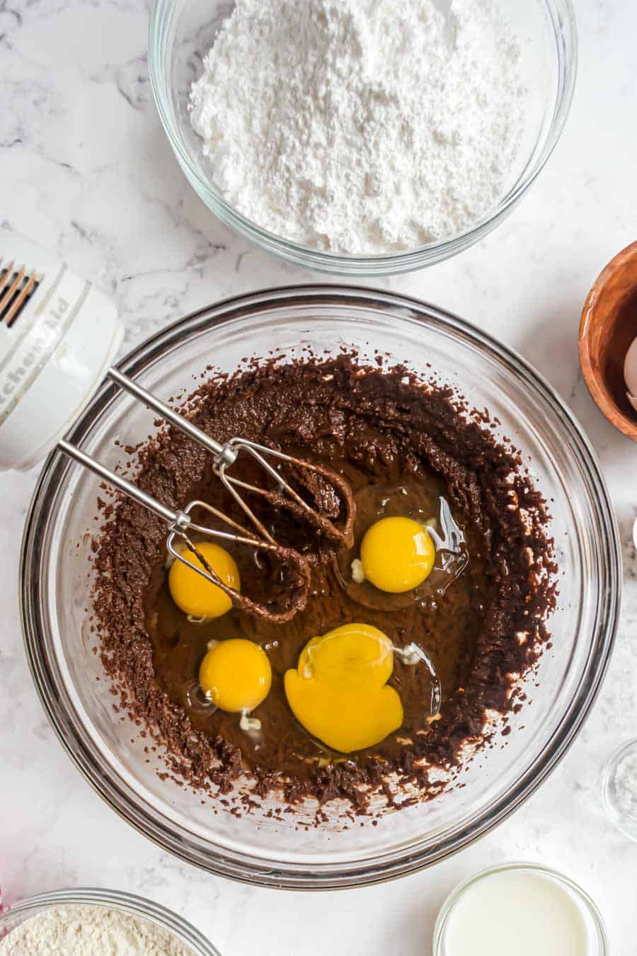 top view of brownie batter with eggs being mixed into it.