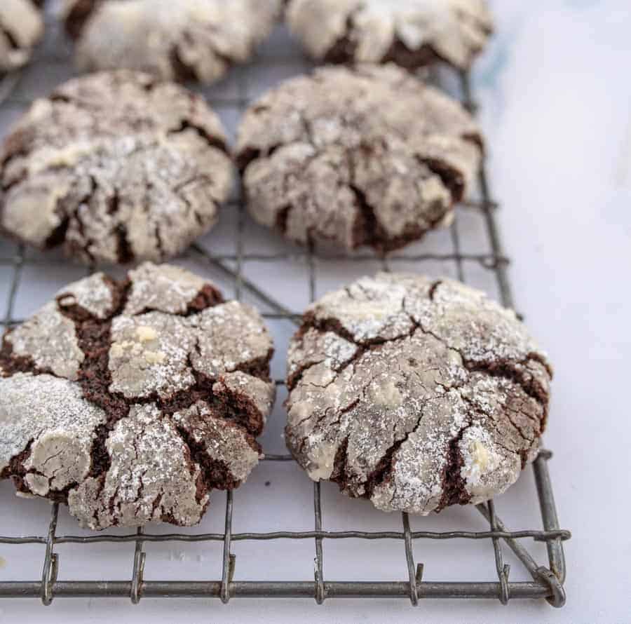 Close up of chocolate crinkle cookies on a drying rack.