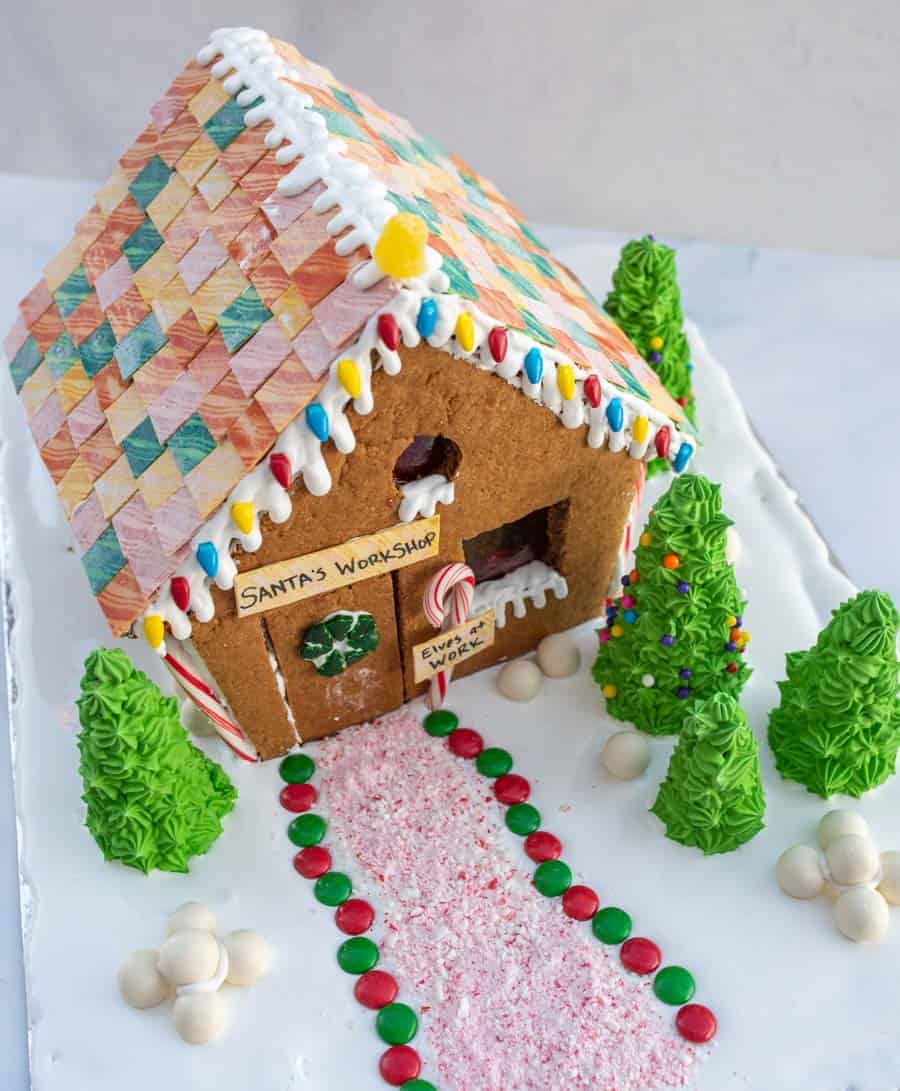traditional gingerbread house beautifully decorated with a sign that says "santa's workshop"