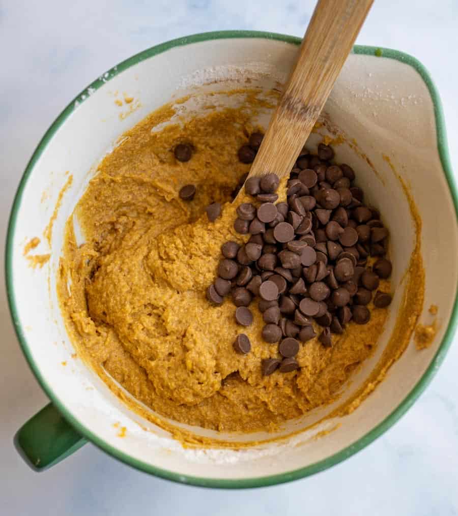 Top view of a bowl with whole wheat pumpkin batter and chocolate chips unmixed.
