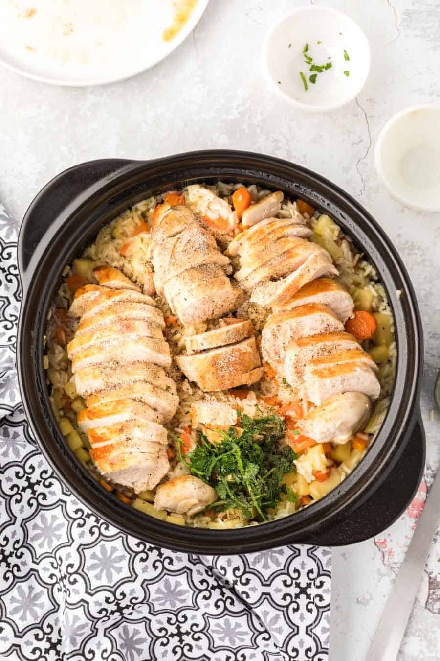 Top view of a pan with chicken and rice in it.