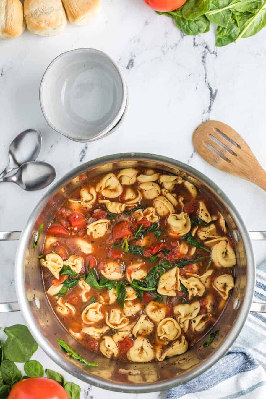 Top view of the completed tortellini soup with tomatoes and spinach.