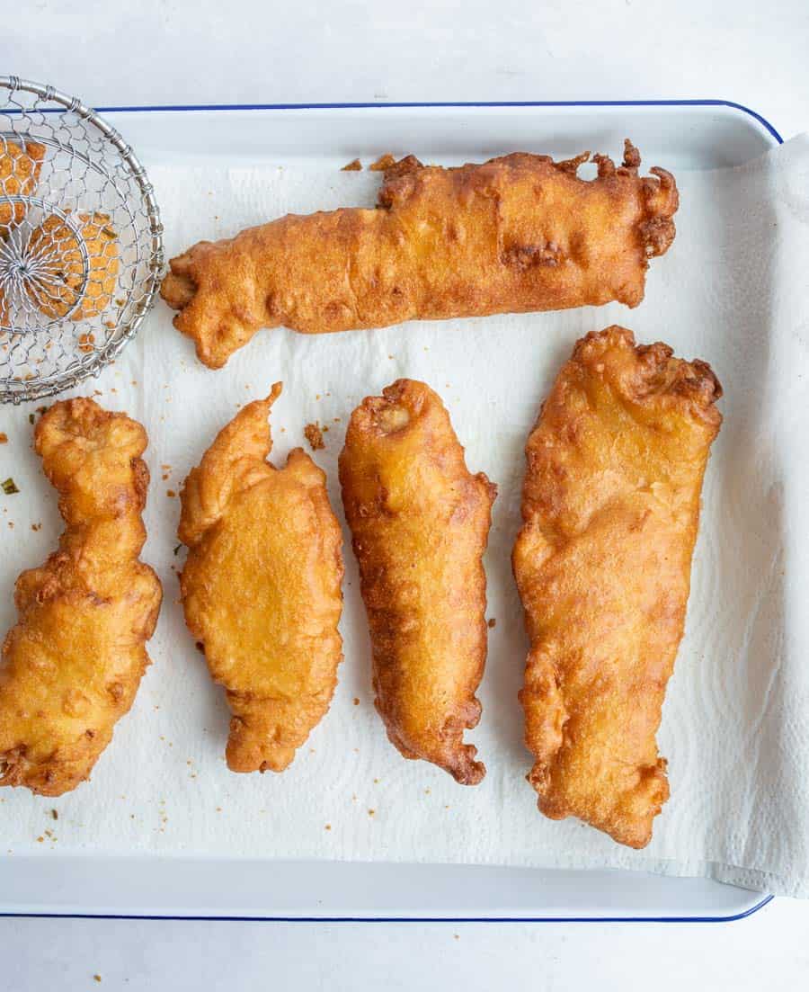 crispy golden deep fried and beer batter fish on a baking dish.