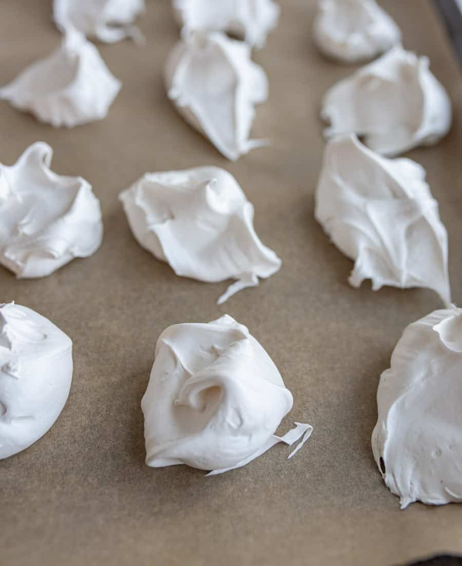 dollops of fluffy looking white divinity candy on parchment.