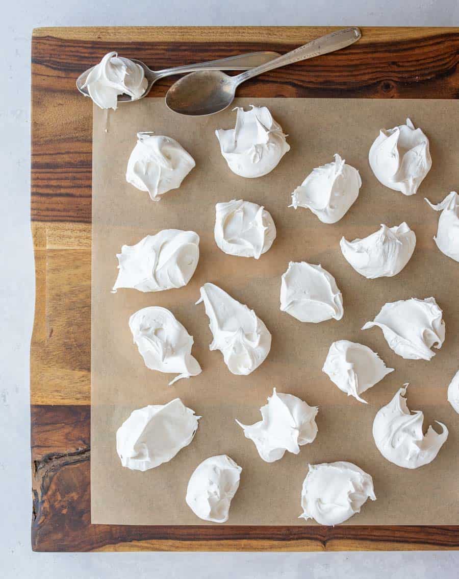 dollops of fluffy looking white divinity candy on parchment top view.