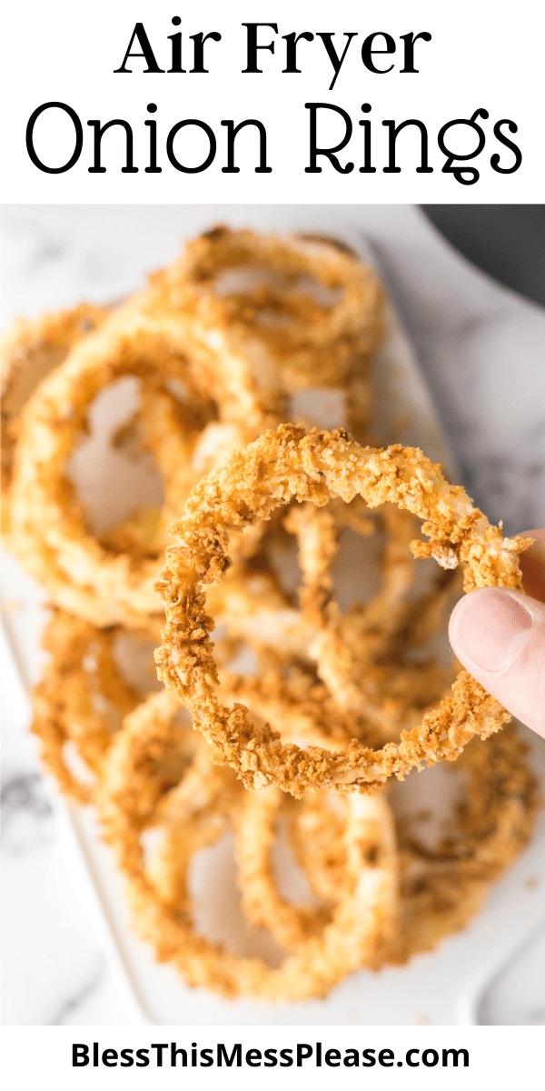 Pin that reads air fryer onion rings with a POV photo holding a ring up close with a plate behind it.