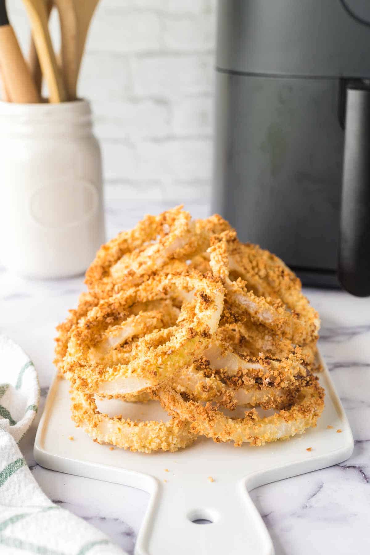 a plate of crispy golden onion rings on a dish.