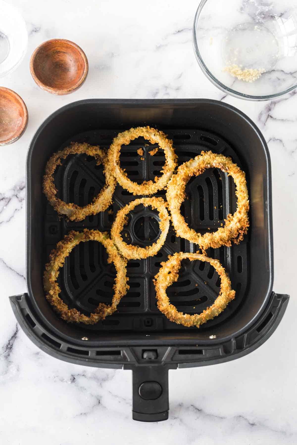 crispy onion rings in the air fryer basket.