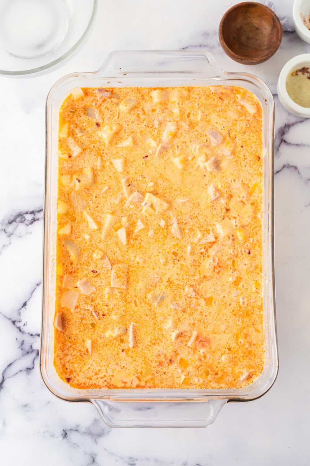 a baking dish of uncooked ham and potato casserole