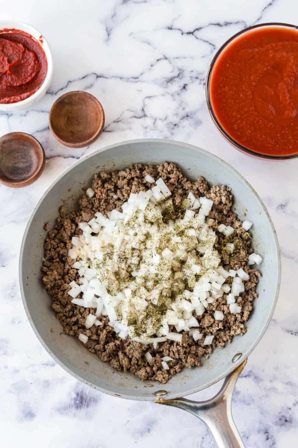ingredients for meat sauce added one by one and a cooking in a pot